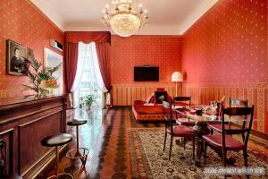 那不勒斯La Casa Sul Nilo的客厅设有红色的墙壁和桌椅