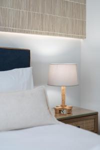伊罗达Elounda Dream House 2的一间卧室配有一张床和一张桌子上的台灯