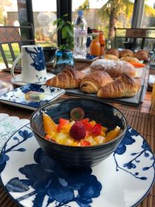 兰斯Les Suites Champenoises的桌上一碗水果,包括糕点和面包