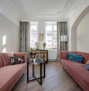 格尔利茨Design-Appartement im Herzen von Görlitz的客厅配有2张粉红色的沙发和1张桌子