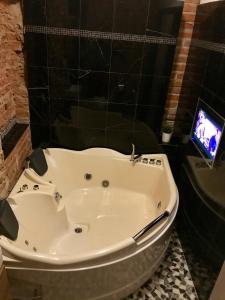 布尔诺Brno center whirlpool apartment的带电视的浴室设有白色浴缸。