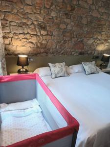 拉斯特雷斯欧蒂米奥酒店的一间卧室设有两张床和石墙