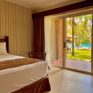 圣克鲁斯卡米诺里尔酒店的一间卧室设有一张床和一个滑动玻璃门