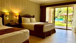 圣克鲁斯卡米诺里尔酒店的酒店客房,设有两张床和滑动玻璃门
