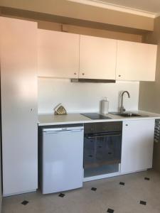 里斯本New Aqueduct View Romantic Apartment in Campolide - 2B的厨房配有白色橱柜、水槽和洗碗机。