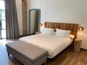 佩雷拉达HOTEL MAS ARET的卧室配有一张白色大床和木制床头板