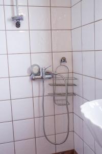 扎戈拉Sunray Luxury Apartment Zagora with piano的白色瓷砖浴室设有淋浴和软管