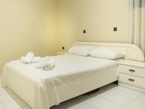 ApolakkiáApartment Lazarous 1的一间卧室配有两张床、白色的床单和毛巾。