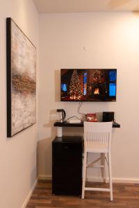 海法Golden Suite Bahai's Garden的一张带白色椅子的桌子和墙上的电视