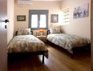 雅典Αcacia House - Fully Equipped Apartment in Glyfada的一间卧室设有两张床和窗户。