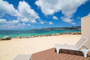 圣马丁岛Sweet Home SXM Baie Nettlé Pieds dans l'eau的海滩上的白色躺椅