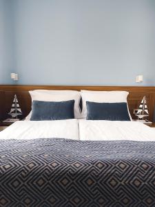皮兰Vila Piranesi Apartments - Parking included的一张带蓝色和白色床单及枕头的床