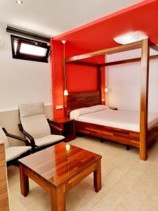 科尼尔-德拉弗龙特拉阿雷西费萨尔瓦多公寓的客房设有两张床、一张沙发和一张桌子。