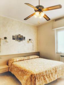斯波托尔诺B&B Hotel Costa Azzurra的一间卧室配有一张带吊扇的床