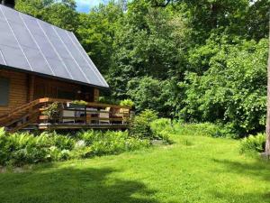 莫德拉Wooden house in the nature的旁边设有太阳能电池板的房子