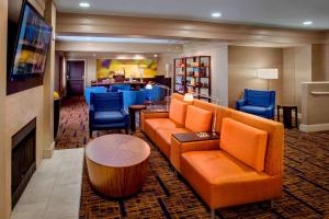 丹弗斯波士顿丹弗斯万怡酒店的酒店大堂设有橙色家具和壁炉
