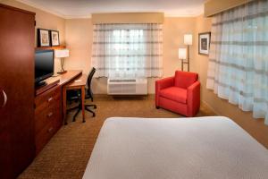 丹弗斯波士顿丹弗斯万怡酒店的酒店客房配有书桌和红色椅子