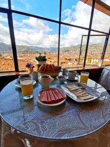 库斯科Hostal Tu Hogar的餐桌上摆放着食物和饮料,享有美景