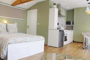 圣艾蒂安Saint Etienne : appartement Châteaucreux 40 M2的一间带白色床的卧室和一间厨房