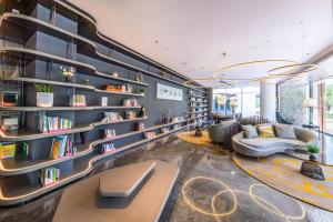 济南济南西站国际会展中心亚朵轻居酒店的一间藏书架和沙发的图书馆