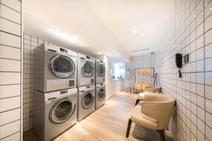南昌南昌红谷滩铜锣湾广场亚朵酒店的洗衣房配有4台洗衣机和烘干机