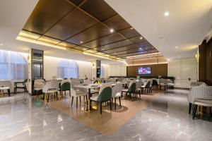 桂林桂林两江四湖象鼻山亚朵酒店的餐厅设有桌椅和平面电视。