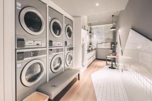 青岛青岛CBD杭州路亚朵酒店的洗衣房配有4台洗衣机和烘干机