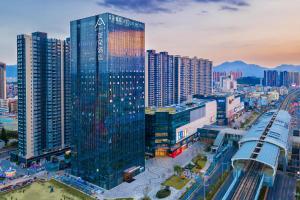 惠州惠州仲恺天益城亚朵酒店的一座高大的玻璃建筑,在城市里,有建筑
