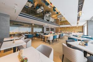重庆重庆西站亚朵酒店的餐厅设有白色的桌子和蓝色的椅子