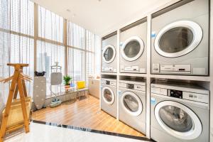 常德常德老西门亚朵酒店的洗衣房配有4台洗衣机和烘干机