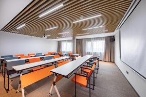 安庆安庆吾悦广场亚朵酒店的一个配有桌椅的空教室和一个黑板