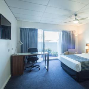 杰拉尔顿海洋中心酒店的酒店客房配有一张床、一张书桌和一张书桌。
