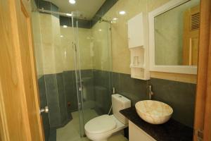 头顿COCA HOTEL & APARTMENT的一间带卫生间和玻璃淋浴间的浴室