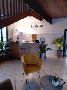 欧里亚克Le Relax的一间设有椅子和桌子的等候室