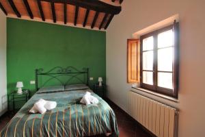 丘西Il casale di Sandra的绿色卧室配有带2条毛巾的床