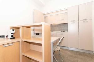 都灵Open Space 53 con Parcheggio in Struttura e Colazione deliziosa的厨房配有白色橱柜、桌子和椅子