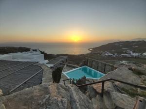 胡拉吉亚White Rock Suites & Villas的海洋和游泳池的日落