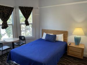 旧金山双峰酒店的一间卧室配有蓝色的床和桌椅