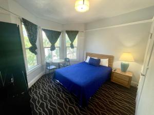 旧金山双峰酒店的一间卧室设有蓝色的床和2个窗户。