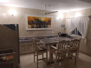 瓦塔穆Garoda House Turtle Bay [ Jacuzzi ☆☆☆☆☆ ] Kilifi的厨房配有桌椅和墙上的绘画作品