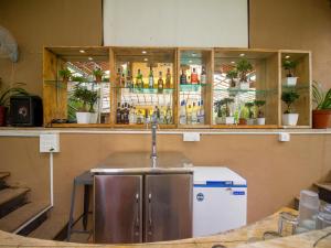 安君纳Verandah - A Beautiful Story, Near Anjuna Beach的一个带水槽的酒吧和一个带瓶子的吧台