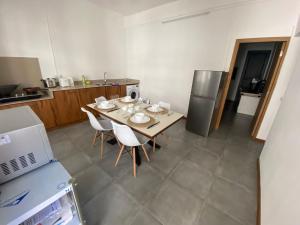 路易港Dragon Nest Apartments的厨房配有桌椅和冰箱。