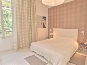 胡安莱潘Villa Saint Charles的卧室配有白色的床和窗户。