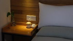 杭州闲处的一张带木制床头板的床和床边的床头柜。