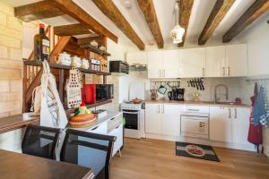 Torcé-en-CharnieL'Aubepine的厨房配有白色橱柜和桌椅