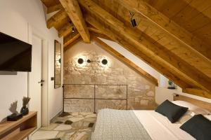 赫瓦尔History Hvar Design Heritage Suites的一间卧室设有一张床和石墙