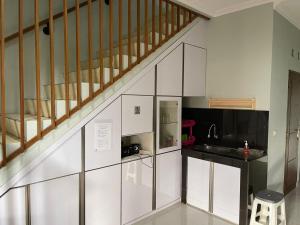 万隆Grand Sofia Family GH的一间厨房,配有白色橱柜和楼梯