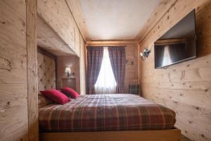 ZuelCortina Deluxe Chalet R&R的一间卧室配有一张带红色枕头的床和一扇窗户