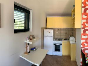 科托尔Apartman Barbara的厨房配有白色冰箱和黄色橱柜