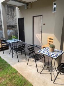 乌隆他尼Hug Udon Hotel的庭院设有两把桌子和椅子。